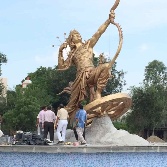 people inspecting statue of lord karna